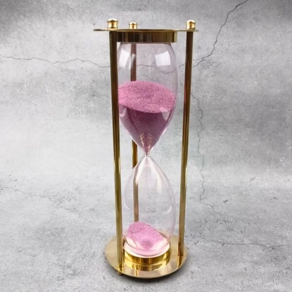 Full view of the decorative 30-minute brass sand timer with pink sand.