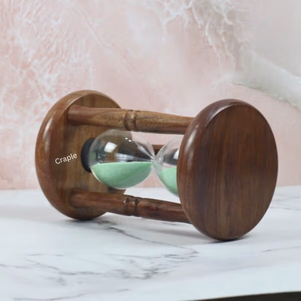 The rosewood hourglass resting on its side, showcasing the rich wood grain of the circular base and pillars.