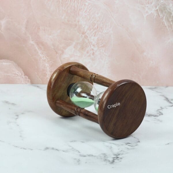 The antique rosewood hourglass on its side, displaying the smooth finish and elegant shape of its base.