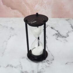 High-angle view of the 5-minute white sand timer, highlighting its minimalist black aluminum design.
