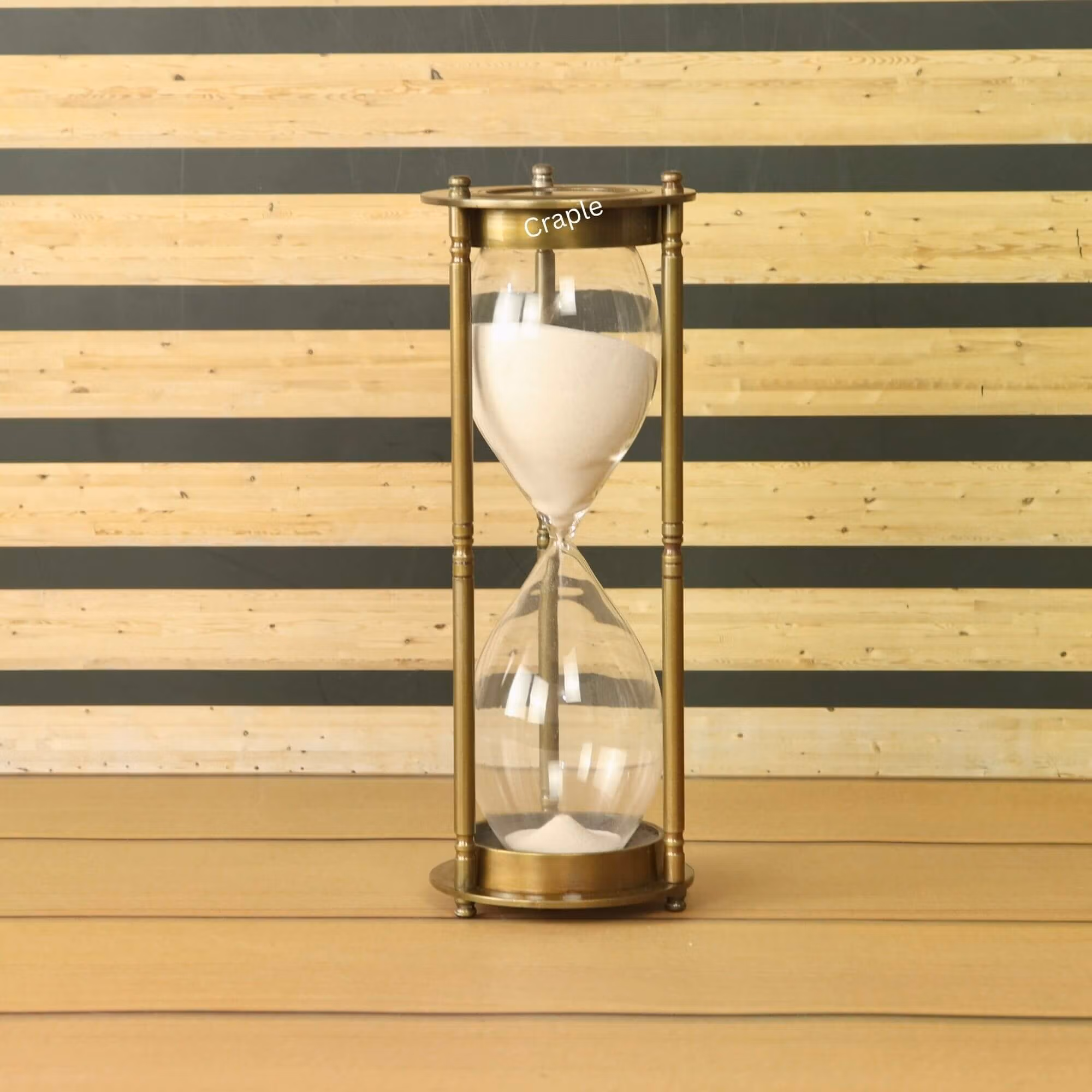 A tall, 60-minute hourglass with white sand, housed in a vintage-style antique brass frame.