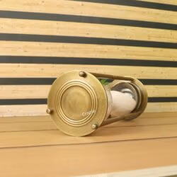 Close-up of the round antique brass base of the 60-minute hourglass, showing its detailed finish.