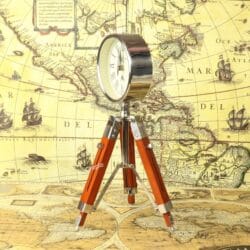 Side profile of the nickel-finished round clock mounted on its adjustable wooden and brass tripod.