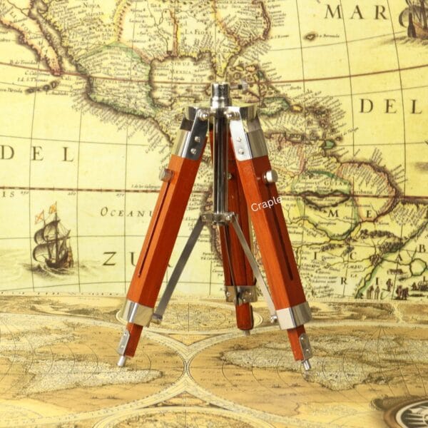 The adjustable wooden and nickel-finished tripod stand shown with its legs folded together.