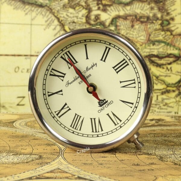 The nickel-finished round desk clock with a classic Roman numeral face, shown detached from its stand.