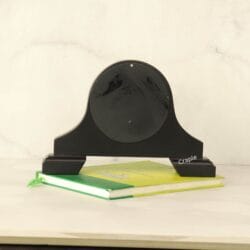 The back of the antique black desk clock, showing its solid wood construction and arched shape.