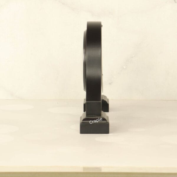 Side profile of the black wooden desk clock, highlighting its sturdy base and elegant silhouette.