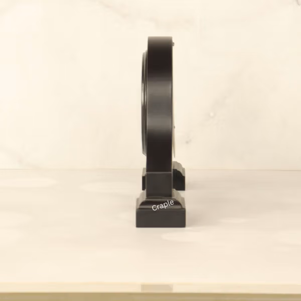 Side profile of the black wooden desk clock, highlighting its sturdy base and elegant silhouette.