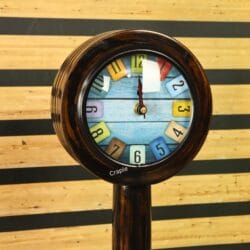 Close-up of the whimsical clock face, showing the multi-colored number tiles on a light blue background.