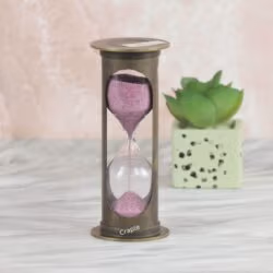 A vintage-style 1-minute hourglass with a cylindrical antique brass frame and sparkling pink sand.