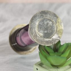 Close-up of the antique brass top of the hourglass, showing the distressed finish and "West London" engraving.
