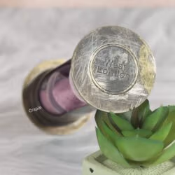 Close-up of the antique brass top of the hourglass, showing the distressed finish and "West London" engraving.