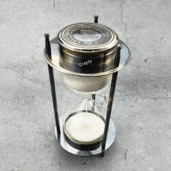 A 5-minute hourglass sand timer with a black antique brass frame and a built-in compass on top.