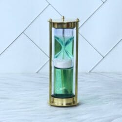 A unique 1-minute floating sand timer with white sand falling through a green liquid, housed in a shiny brass frame.