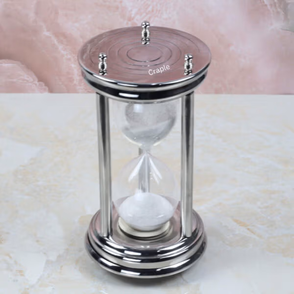 High-angle view of the steel sand timer, detailing the engraved circular pattern on the top plate.