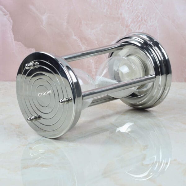 The 10-minute steel hourglass resting horizontally, showcasing its sturdy pillar construction and white sand.