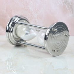 Angled side view of the modern steel sand timer, highlighting its reflective, polished finish.