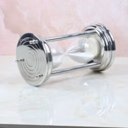 The white sand hourglass viewed from the side while lying down, focusing on the round steel base.