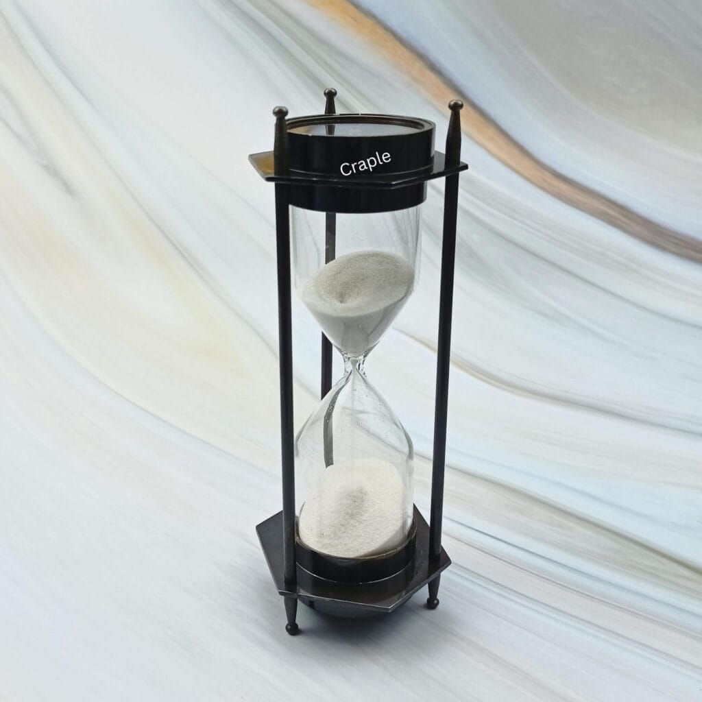 Vintage-style 3-minute hourglass sand timer with a built-in compass, crafted from brass with a black antique finish.