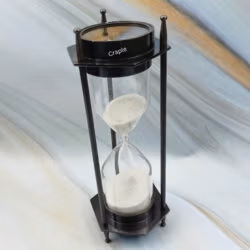 A three-quarter view of the dual compass sand timer, showing both the hourglass and the compass top.