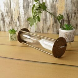 Close-up of the round brass base of the nautical sand timer while it's lying on its side.