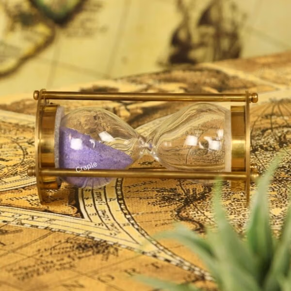 Angled side view of the miniature brass sand timer, perfect for a desktop or shelf display.