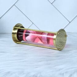 The pink floating hourglass sand timer tilted on its side, with the pink sand collected at one end.
