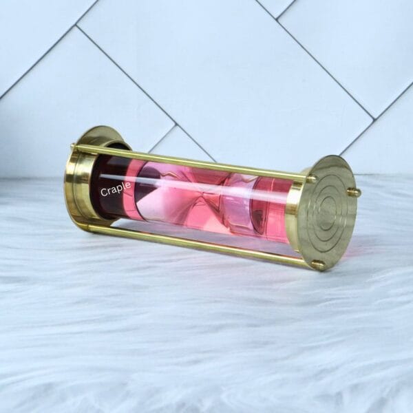 The pink floating hourglass sand timer tilted on its side, with the pink sand collected at one end.