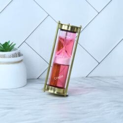 The pink liquid sand timer tilted at an angle, with sand flowing to measure a one-minute interval.