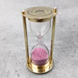 Angled view of the Royal Navy sand timer, highlighting its solid brass construction and glass bulb.