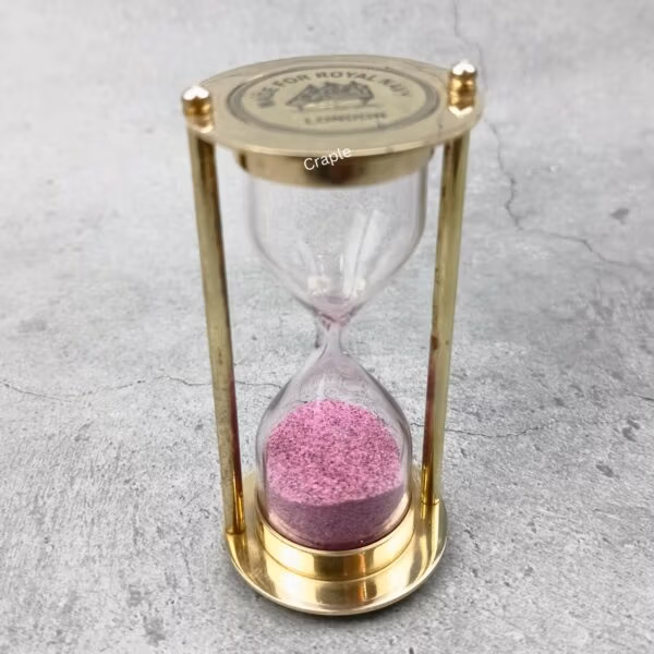 Angled view of the Royal Navy sand timer, highlighting its solid brass construction and glass bulb.