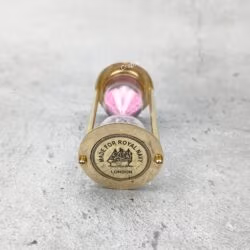 Close-up of the top of the brass hourglass, showing the detailed "Made for Royal Navy London" engraving.