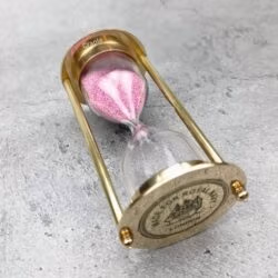 The pink sand and brass 3-minute timer shown from an angled side profile.