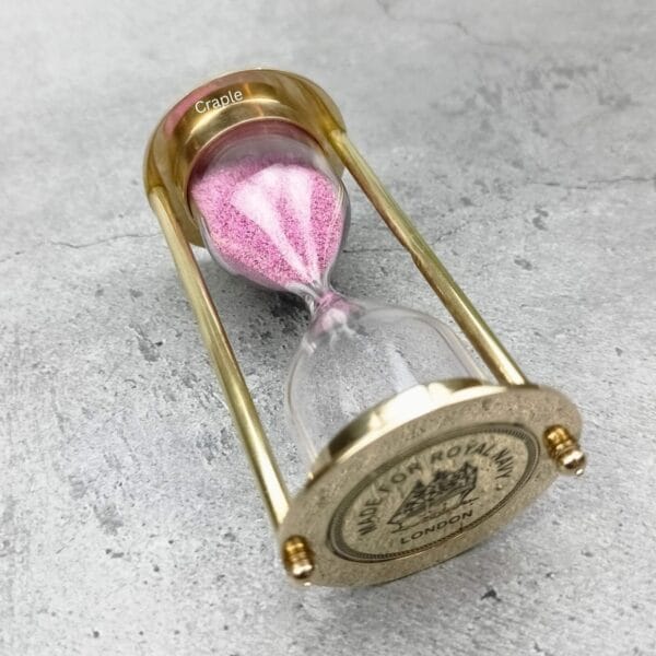 The pink sand and brass 3-minute timer shown from an angled side profile.