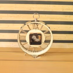 The back of the silver skeleton desk clock, showing the central quartz battery movement.