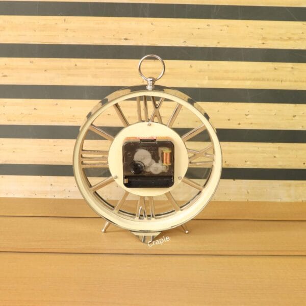 The back of the silver skeleton desk clock, showing the central quartz battery movement.