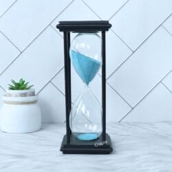 Modern 30-minute hourglass with a sleek black antique finish frame and serene sky blue sand.