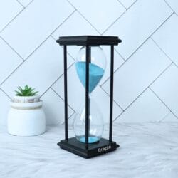 A tall black hourglass with light blue sand, shown from a slight angle against a white background.