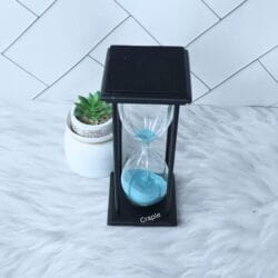 High-angle view of the black hourglass, showing the top of the frame and the sky blue sand inside.