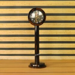 A tall handcrafted wooden pedestal clock with a brown-black antique finish and a round, uniquely patterned face.