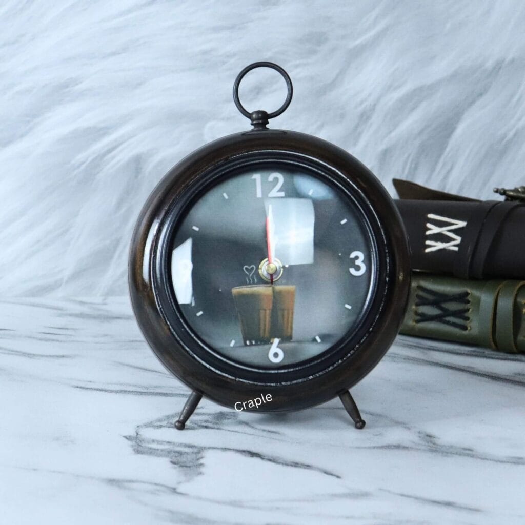 An antique wooden desk clock in a round teacup shape with a brown-black finish and a unique candle-themed dial.