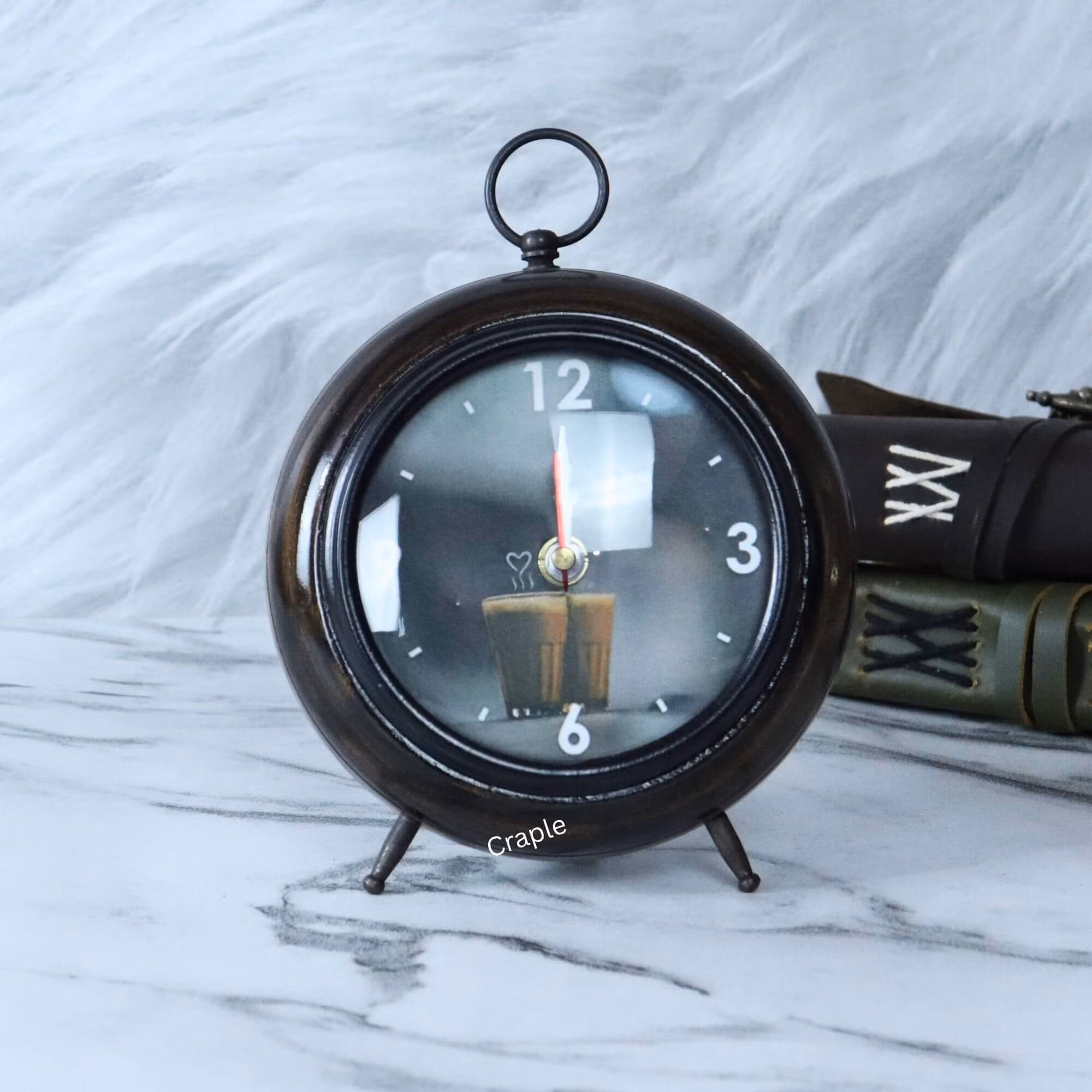 An antique wooden desk clock in a round teacup shape with a brown-black finish and a unique candle-themed dial.