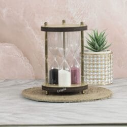 A unique 3-in-1 hourglass with a wooden frame and antique brass pillars, featuring timers with black, white, and pink sand.