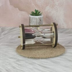 Side profile of the decorative multi-sand timer, highlighting its wooden frame and antique-finish brass supports.