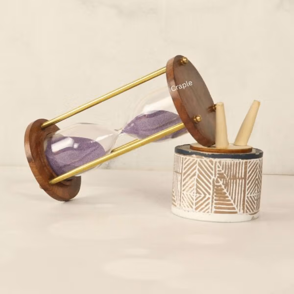 The 5-minute purple sand hourglass used as a stylish desktop accessory next to a pen holder.