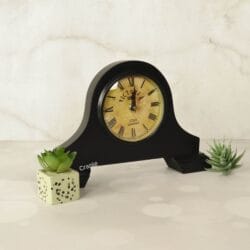 Vintage Victoria-style black wooden desk clock displayed as a decorative piece next to a succulent.