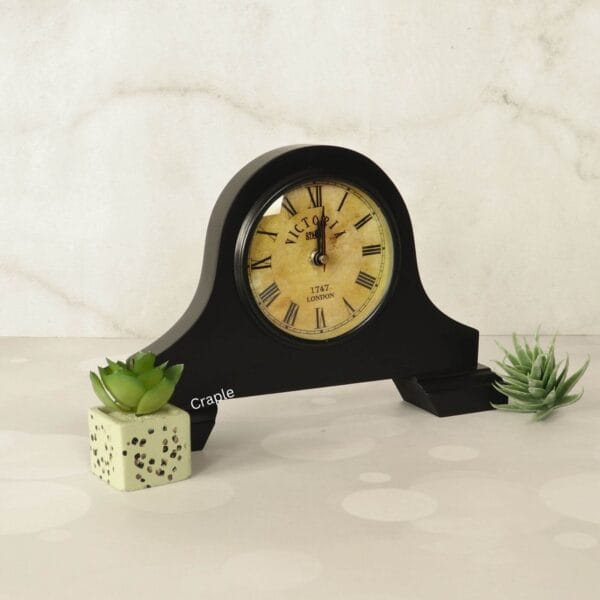 Vintage Victoria-style black wooden desk clock displayed as a decorative piece next to a succulent.