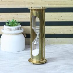 Side profile of the tall brass hourglass, highlighting its pillar construction and polished finish.