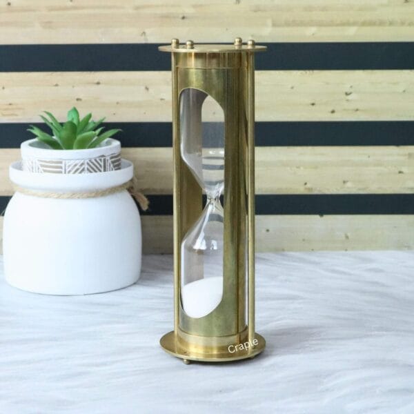 Side profile of the tall brass hourglass, highlighting its pillar construction and polished finish.