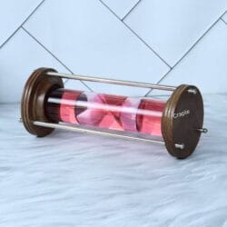 Horizontal view of the red liquid hourglass, focusing on the movement of the pink timer inside the glass tube.